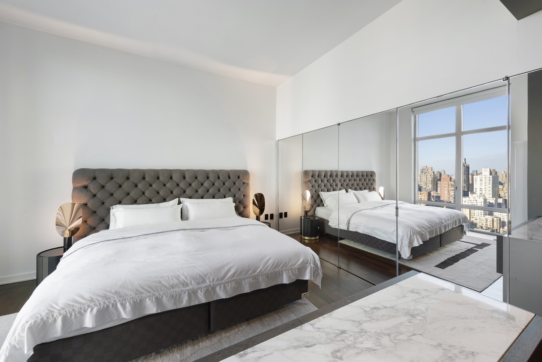 207 East 57th Street, Unit 34A Manhattan, NY 10022 - Photo 9 of 22 a bedroom with a bed and a night stand