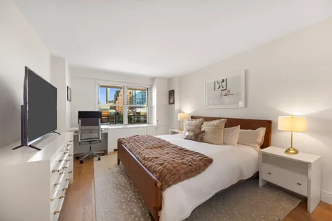 a bedroom with a large bed and a flat screen tv