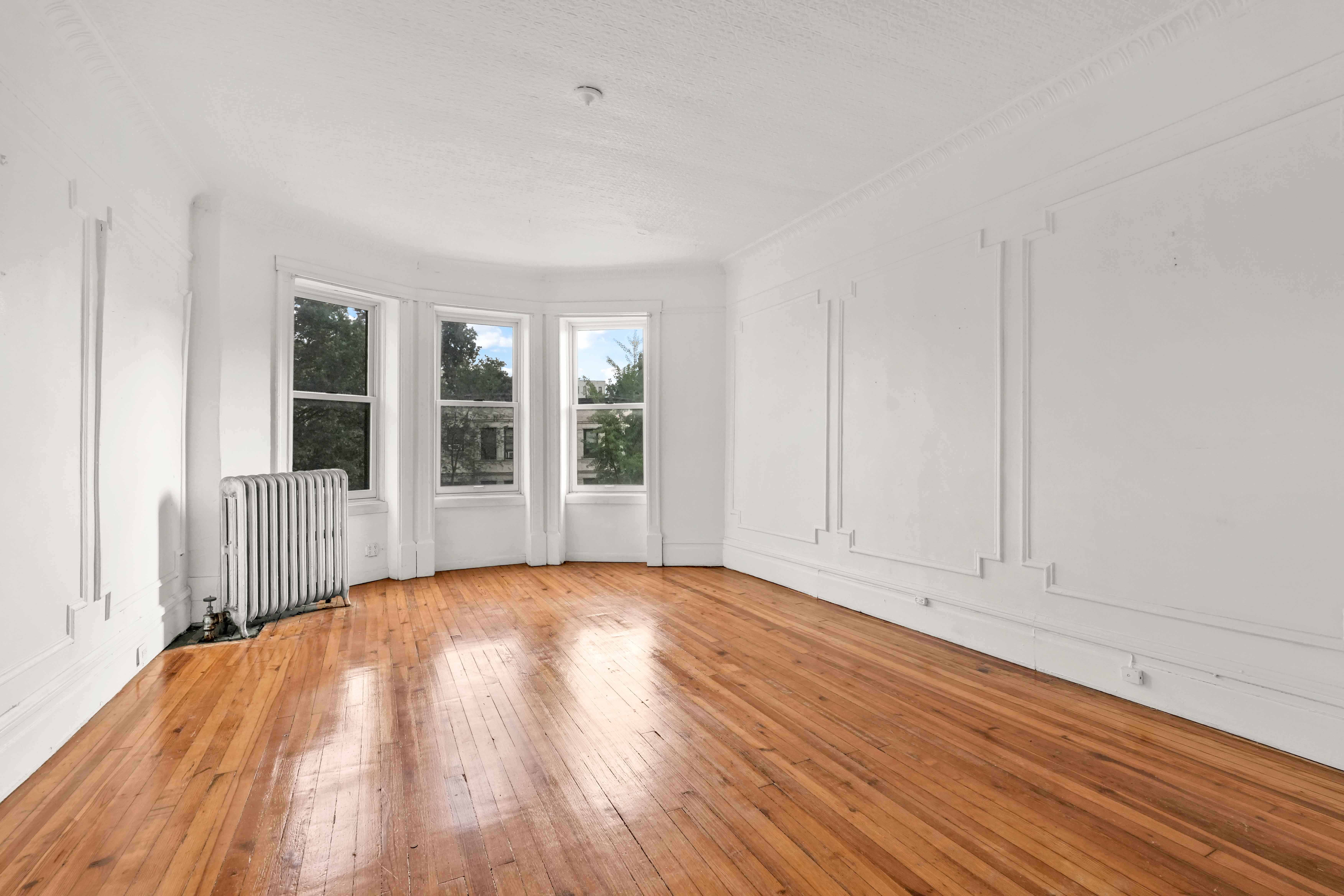 278 Lefferts Avenue Brooklyn, NY 11225 - Photo 6 of 56 a view of an empty room with wooden floor and a window