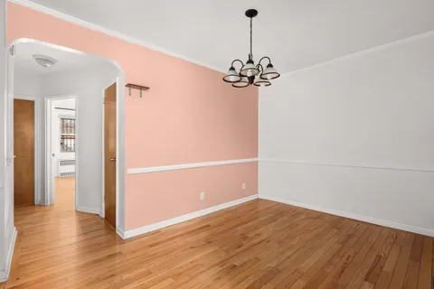 a view of a room with wooden floor and chandelier