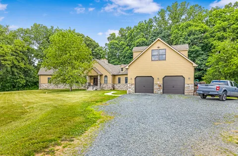 a view of a house with backyard and sitting area