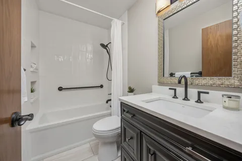 a bathroom with a granite countertop sink toilet and shower