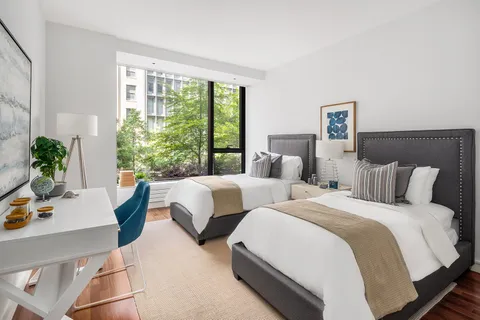 a bedroom with two beds and a large window