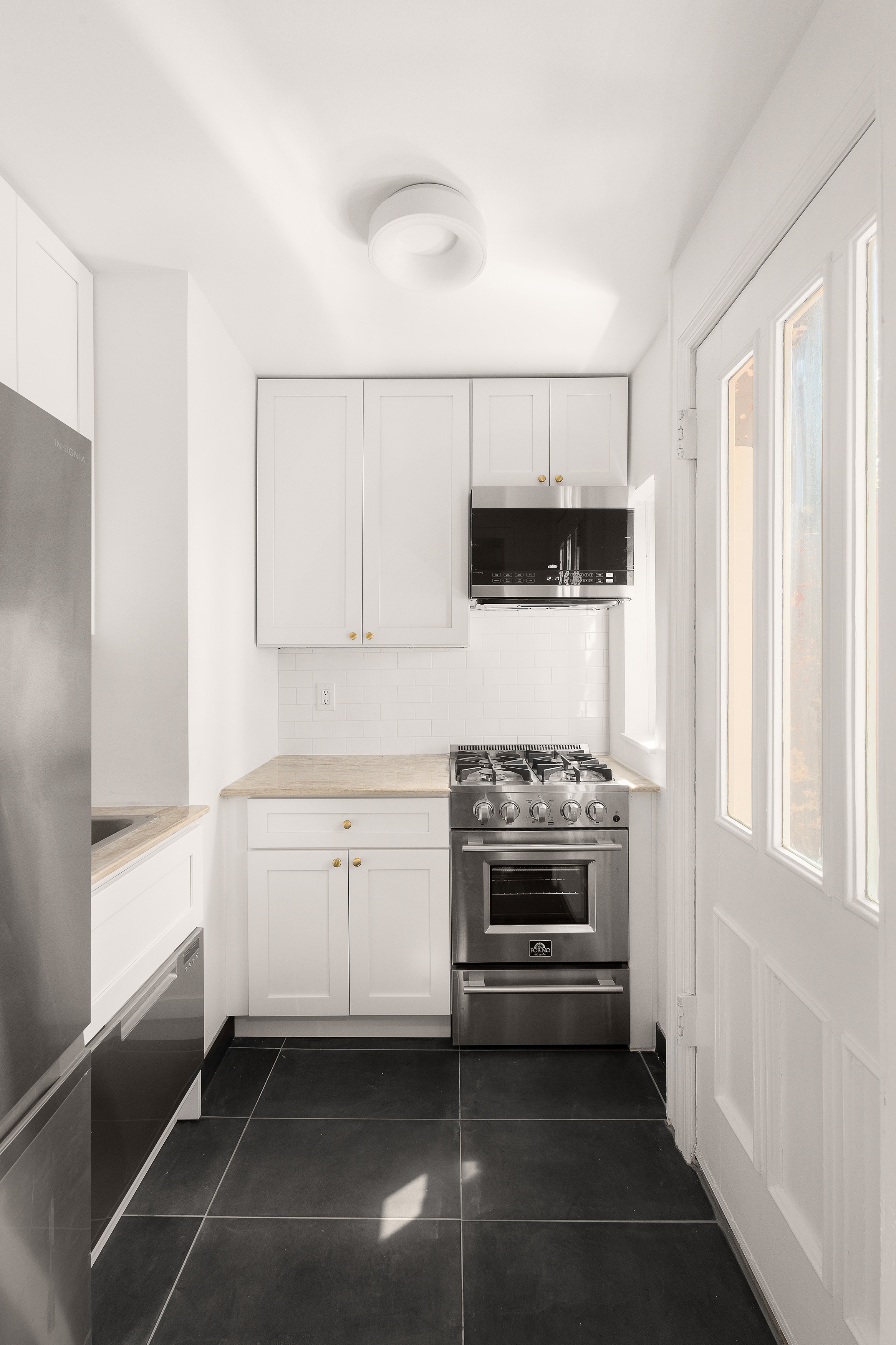 176 Warren Street, Unit GARDEN Brooklyn, NY 11201 - Photo 7 of 9 a kitchen with granite countertop white cabinets and white appliances