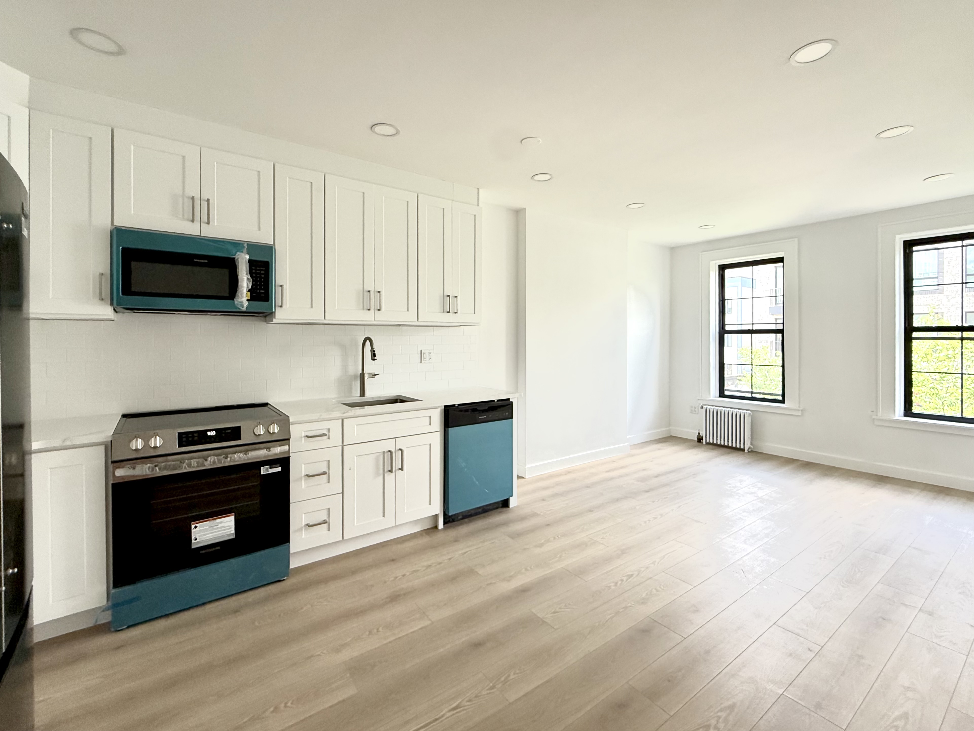 985 Rogers Avenue, Unit 3 Brooklyn, NY 11226 - Photo 2 of 10 a kitchen with stainless steel appliances granite countertop a stove a sink and a microwave