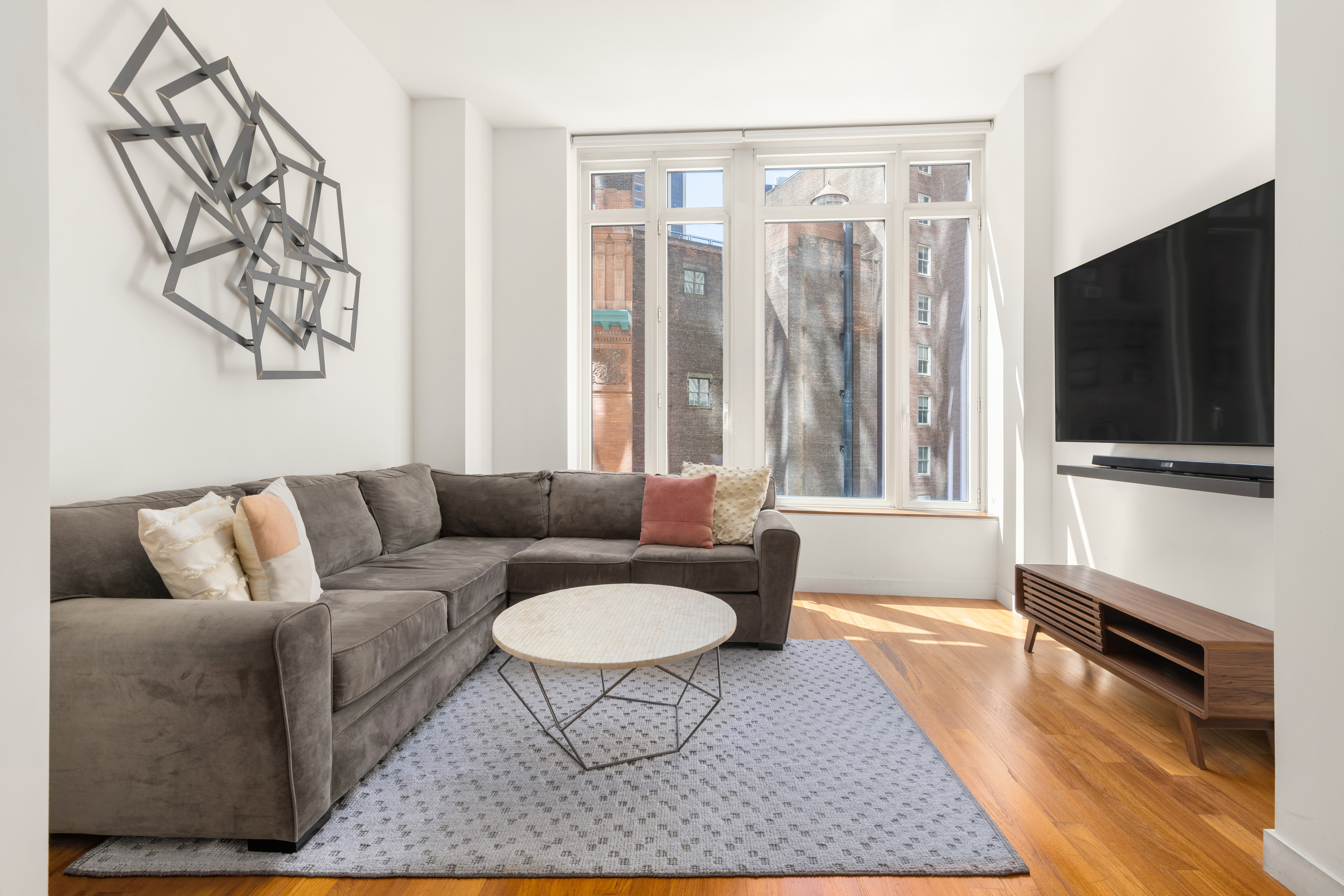 a living room with furniture a flat screen tv and a rug