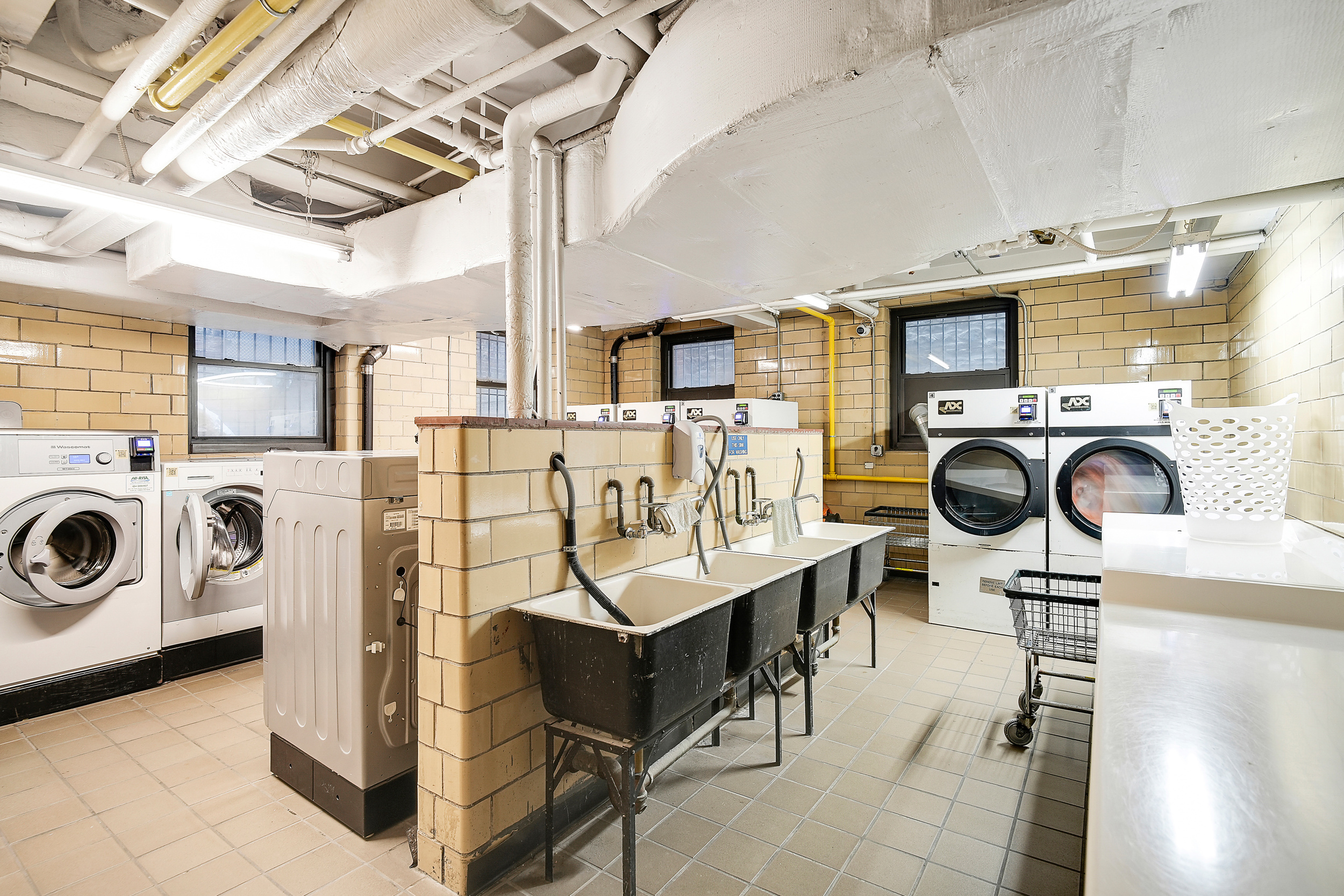 135 East 54th Street, Unit 12M Manhattan, NY 10022 - Photo 9 of 10 a view of a kitchen with sink washer and dryer