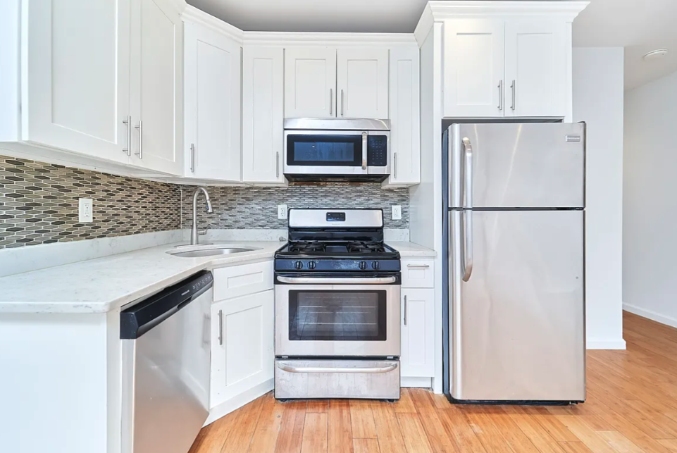 705 Schenck Avenue Brooklyn, NY 11207 - Photo 3 of 8 a kitchen with a refrigerator and a stove
