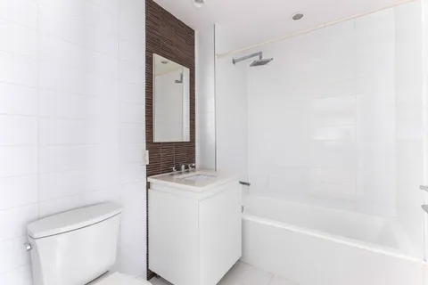 a bathroom with a granite countertop sink a toilet and bathtub