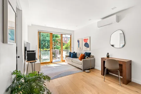 a living room with furniture a large window and a potted plant