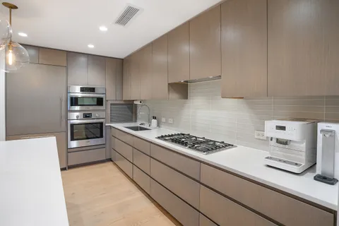 a kitchen with stainless steel appliances kitchen island granite countertop a stove and a refrigerator