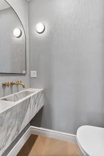 a bathroom with a granite countertop sink and a toilet
