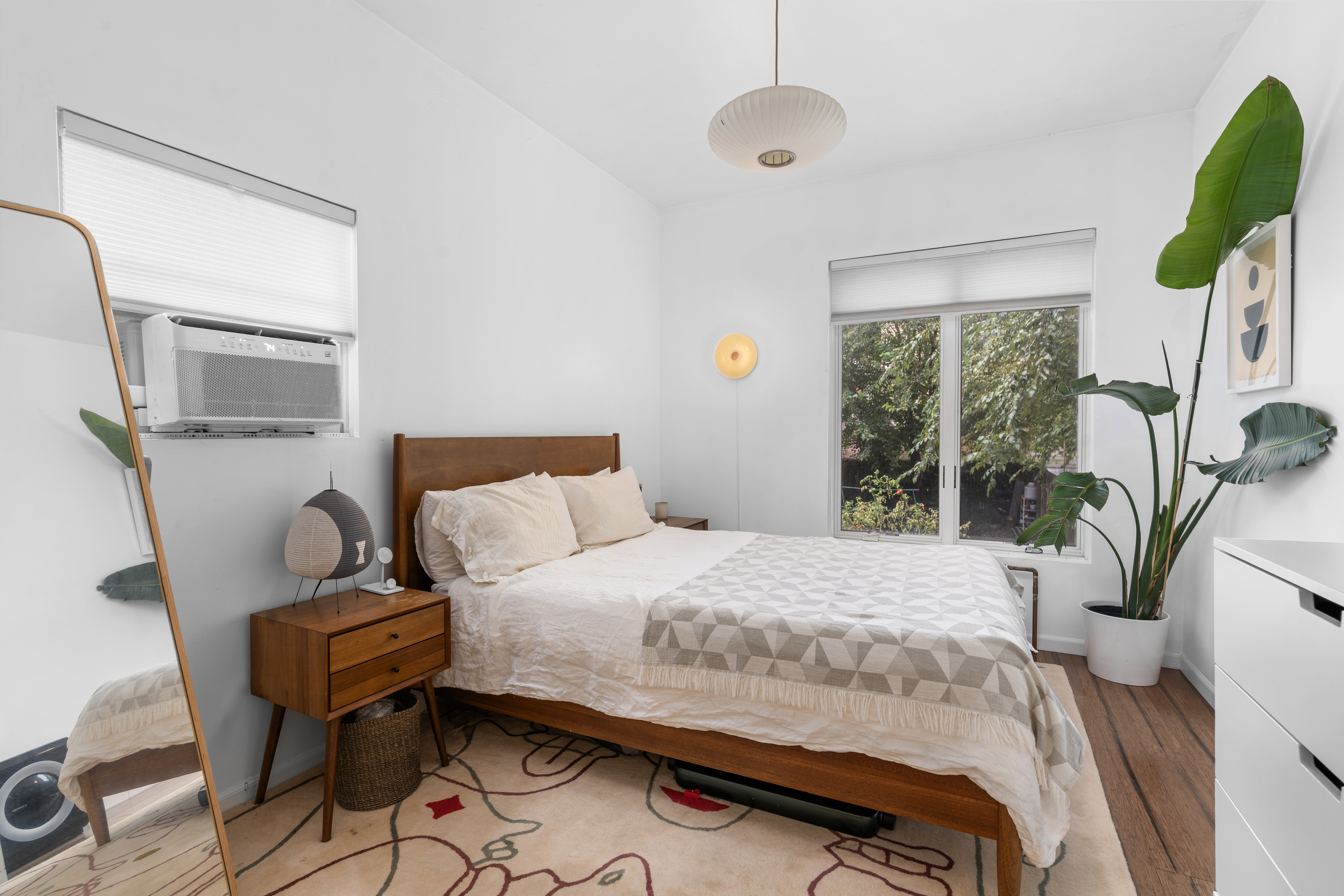 660 Saint Marks Avenue Brooklyn, NY 11216 - Photo 16 of 21 a bedroom with a bed table flowerpot and window