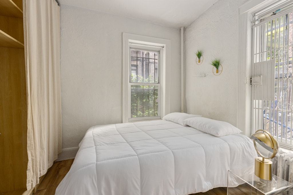 427 East 6th Street, Unit 1R Manhattan, NY 10009 - Photo 2 of 8 a bedroom with a bed window and glass door