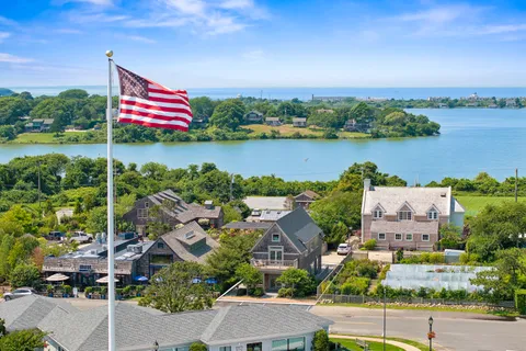 an aerial view of residential houses with outdoor space and lake view