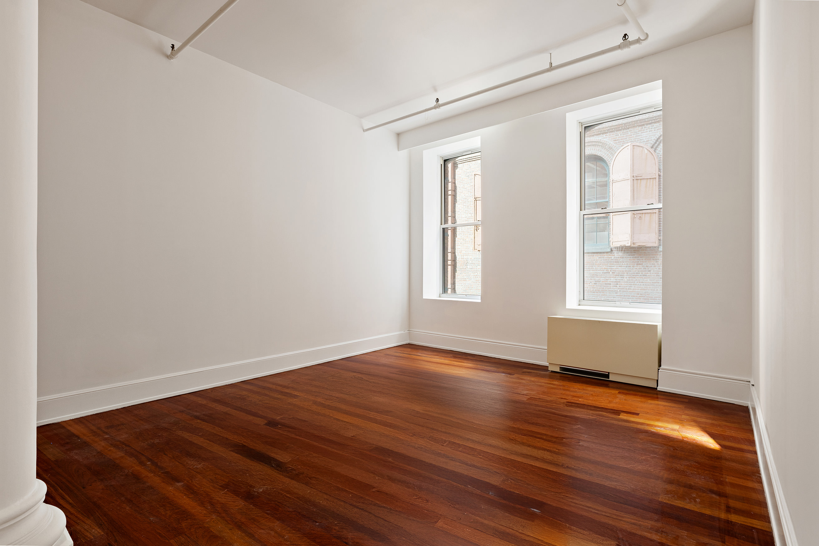 285 Lafayette Street, Unit 2B Manhattan, NY 10012 - Photo 12 of 19 an empty room with wooden floor and windows