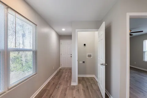 a view of a hallway with wooden floor and a window