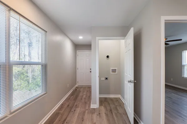 a view of a hallway with wooden floor and a window