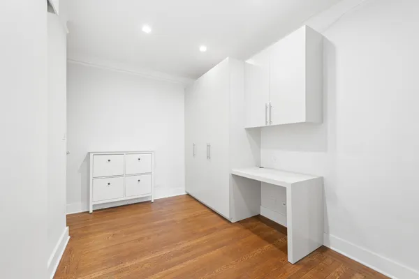 a view of an empty room with cabinet and a window