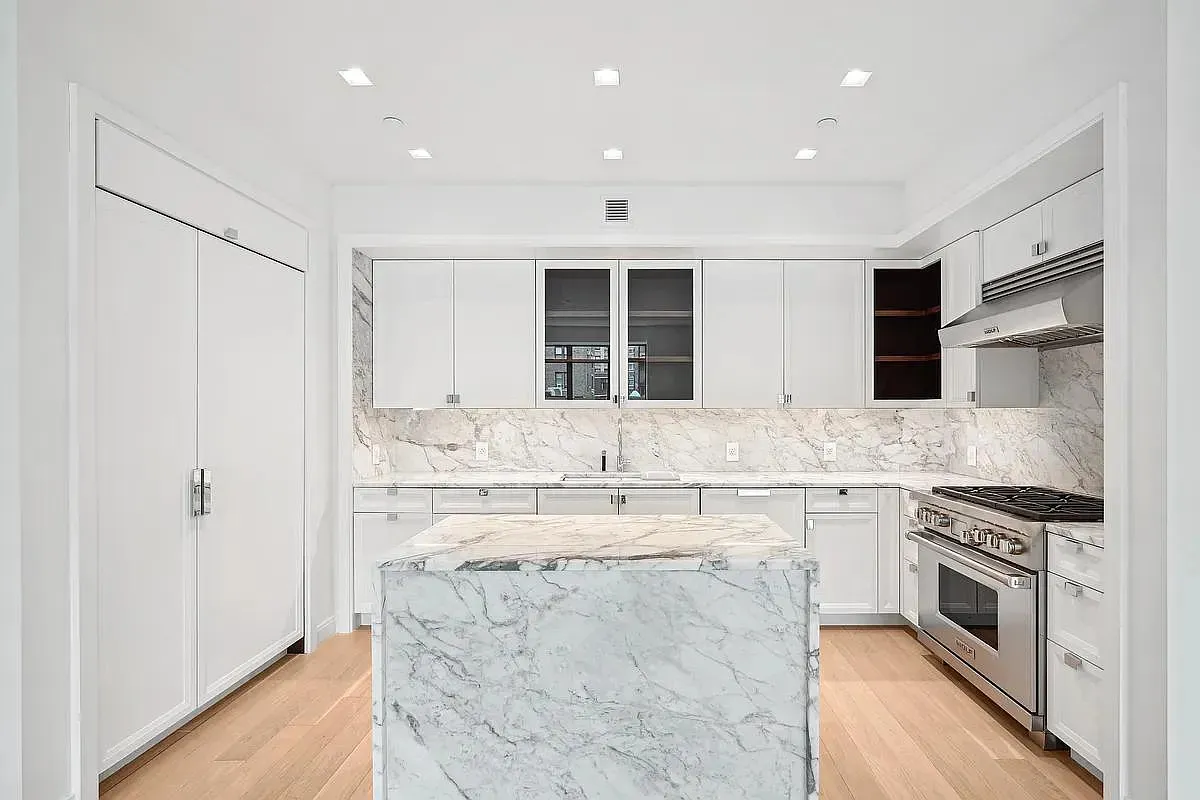 a large kitchen with stainless steel appliances granite countertop a stove and a sink