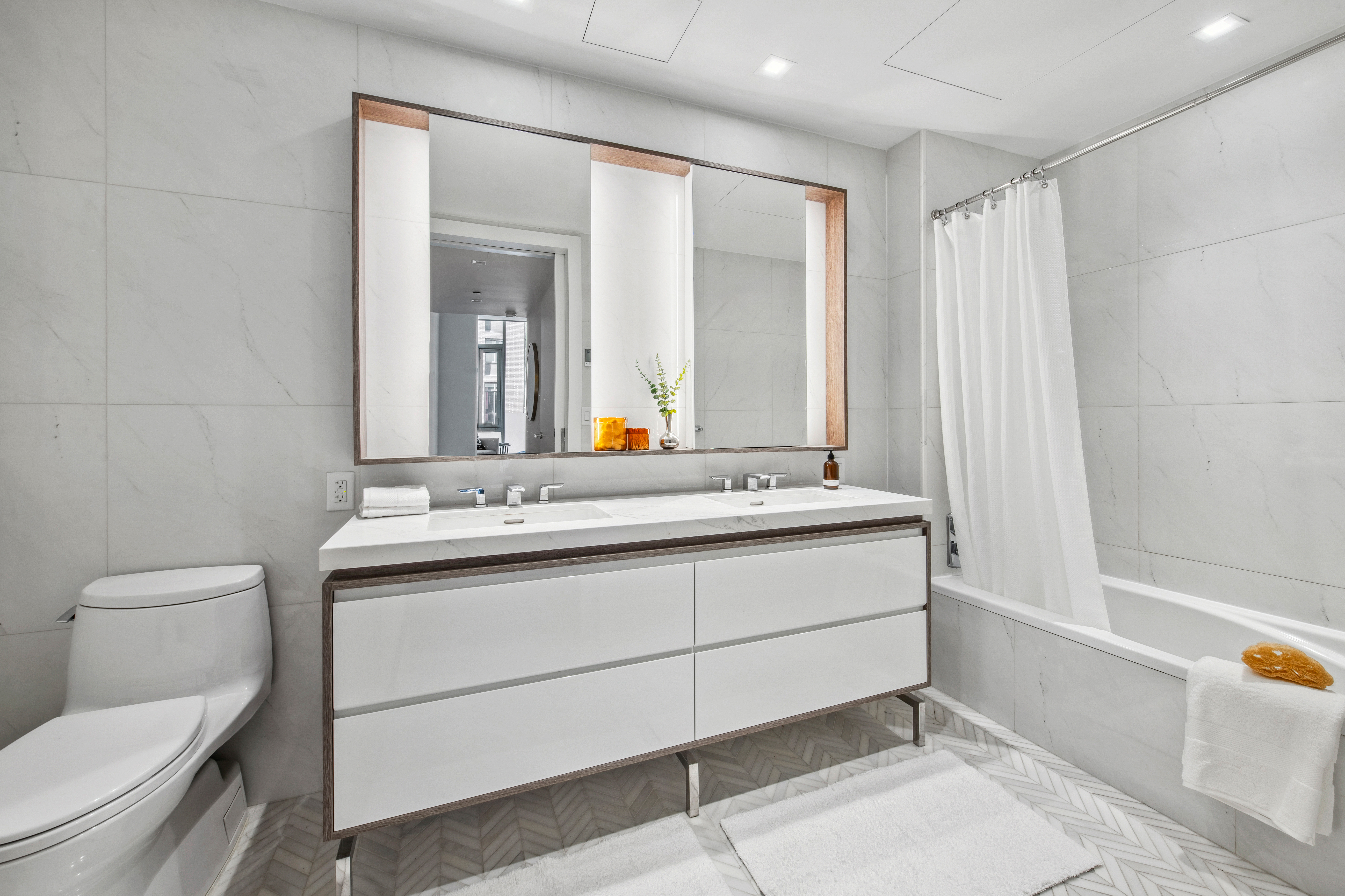 505-513 West 43rd Street, Unit 2B Manhattan, NY 10036 - Photo 6 of 18 a bathroom with a sink mirror vanity and toilet