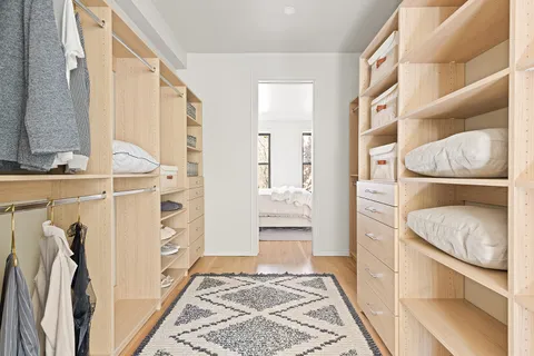 a view of walk in closet with clothes and shoes
