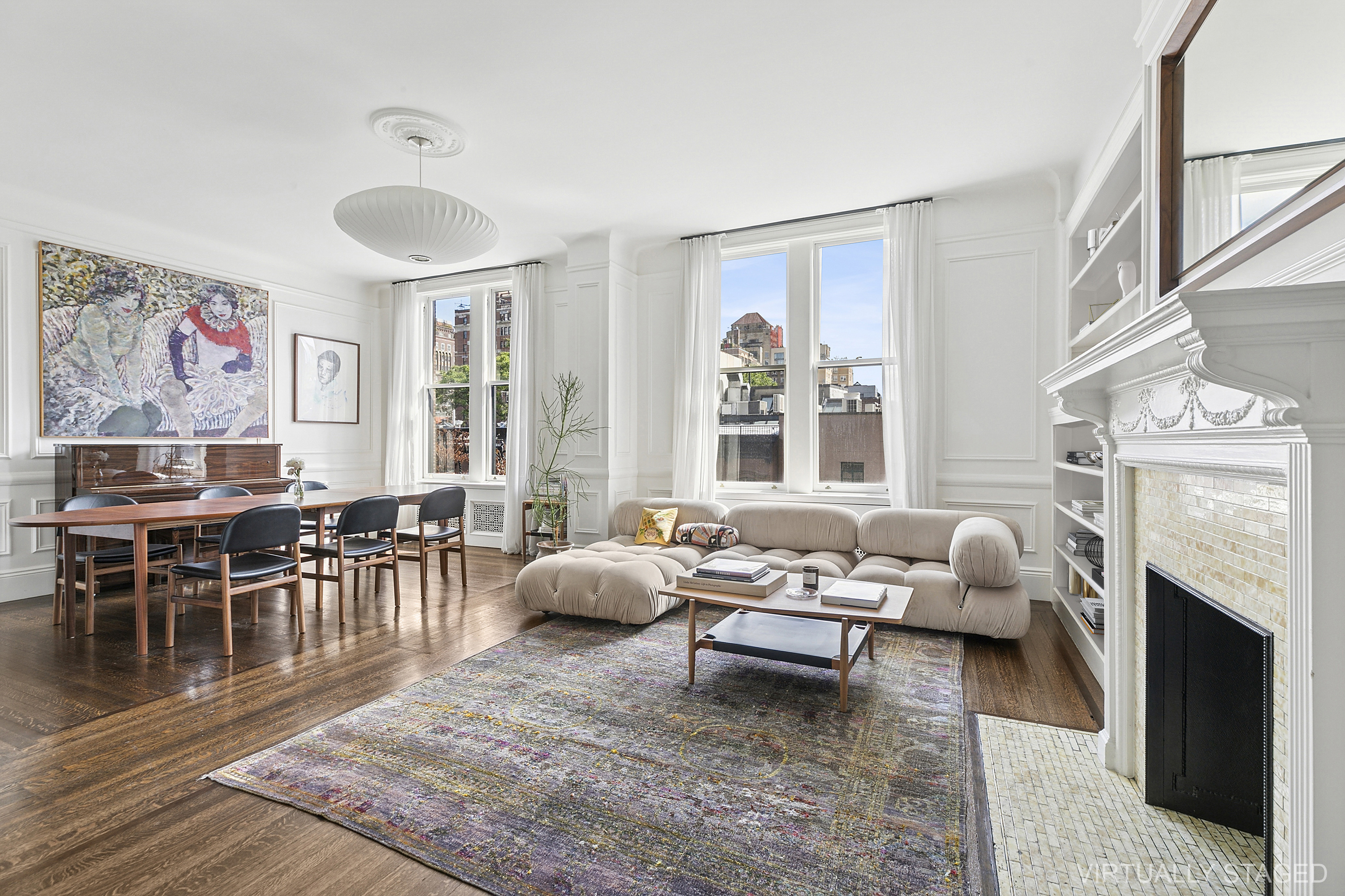 a living room with furniture a fireplace and a large window