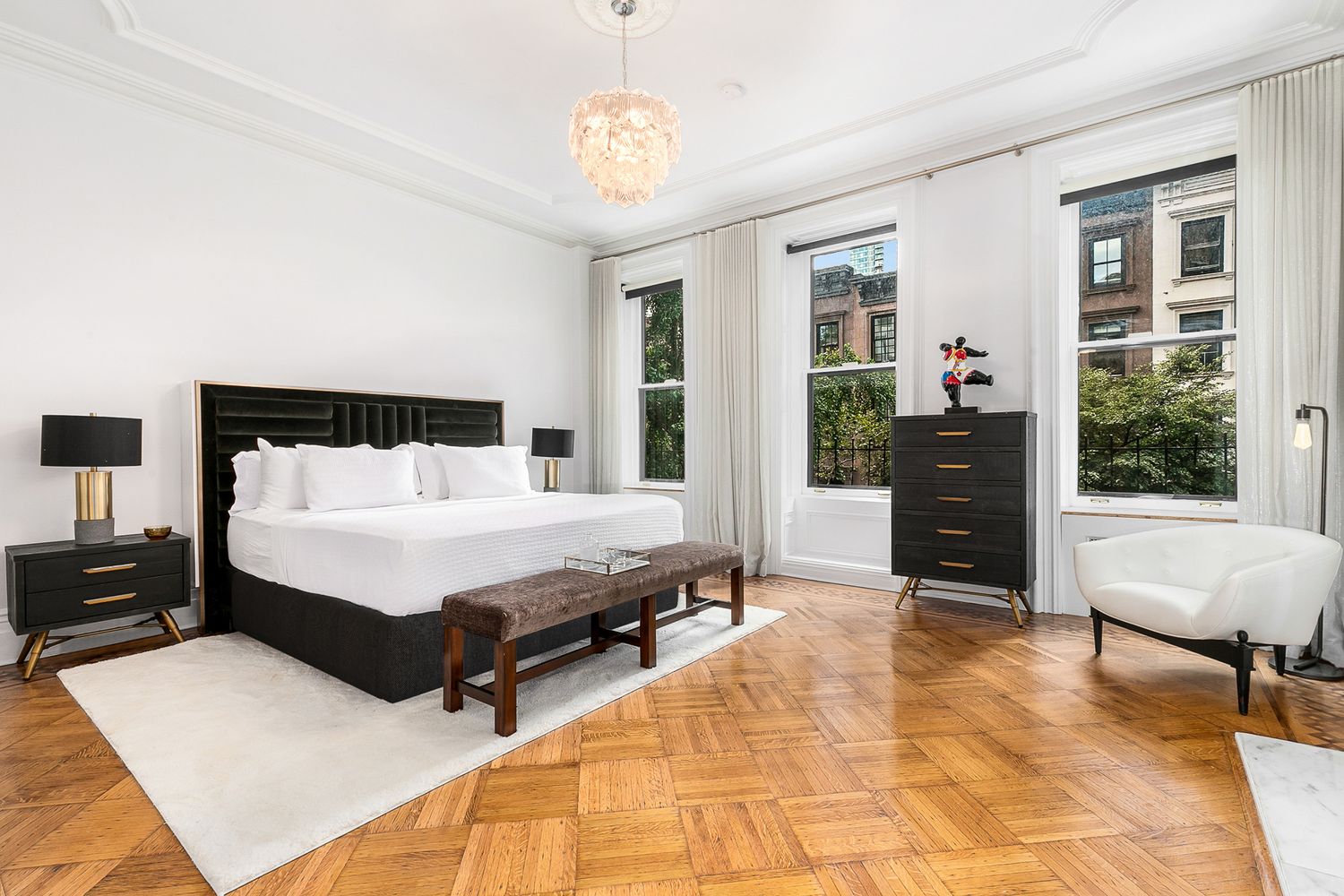 209 East 61st Street Manhattan, NY 10065 - Photo 9 of 27 a spacious bedroom with a bed and wooden floor