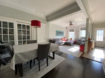 a living room with furniture a chandelier and a large window