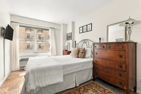 a bedroom with a bed and with a mirror on dresser