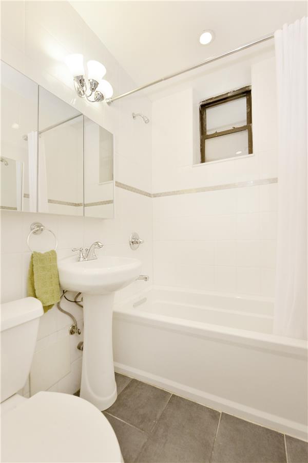 660 Riverside Drive, Unit 1B Manhattan, NY 10031 - Photo 4 of 5 a bathroom with a sink a toilet and shower