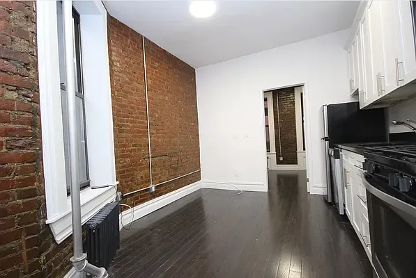 a view of a kitchen with wooden floor and a fireplace