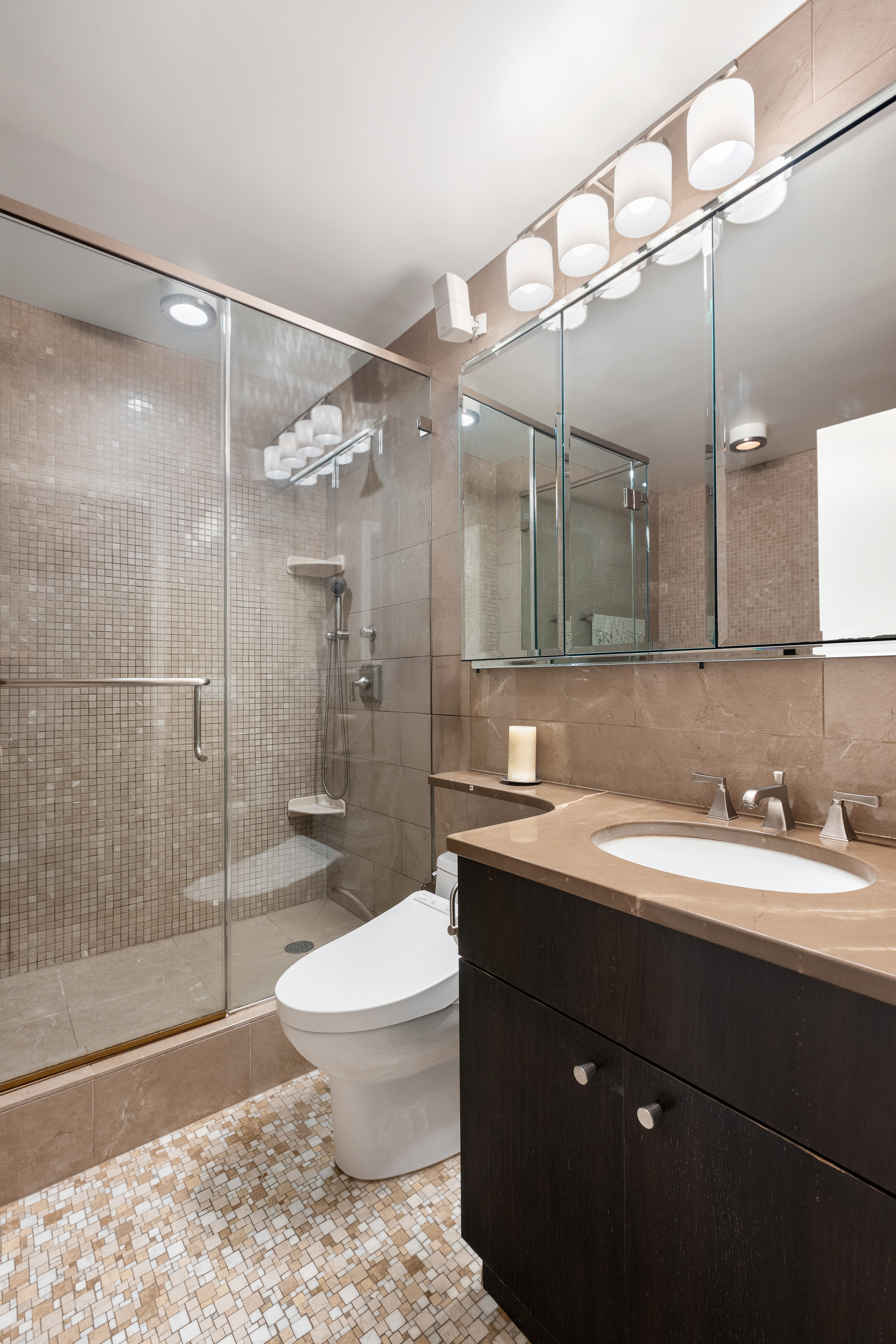 347 West 57th Street, Unit 25AB Manhattan, NY 10019 - Photo 10 of 21 a bathroom with a sink a toilet and shower