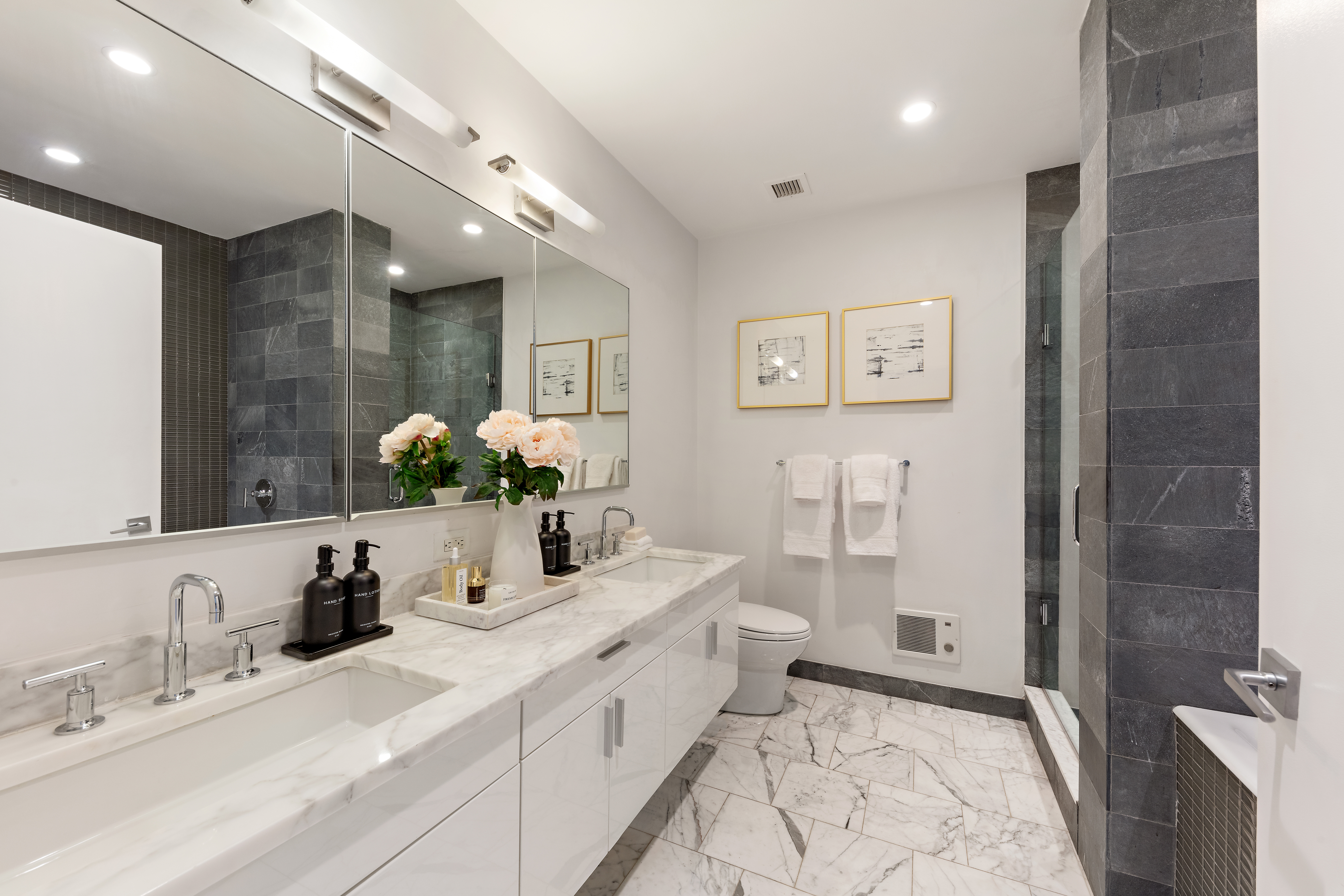 300 East 79th Street, Unit 2A Manhattan, NY 10075 - Photo 8 of 11 a bathroom with a double vanity sink mirror and shower