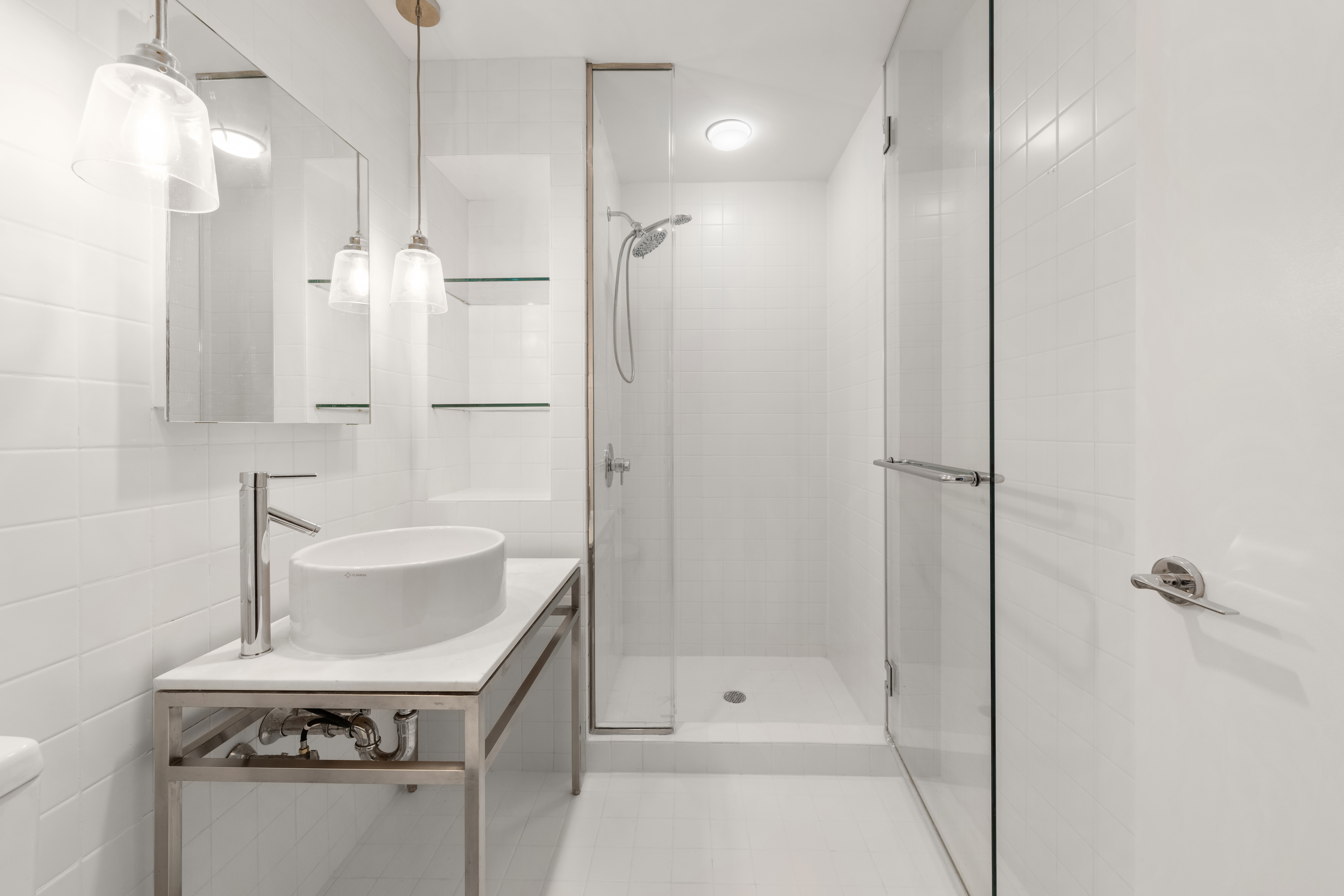 15 Broad Street, Unit 710 Manhattan, NY 10005 - Photo 7 of 11 a bathroom with a sink a toilet and shower