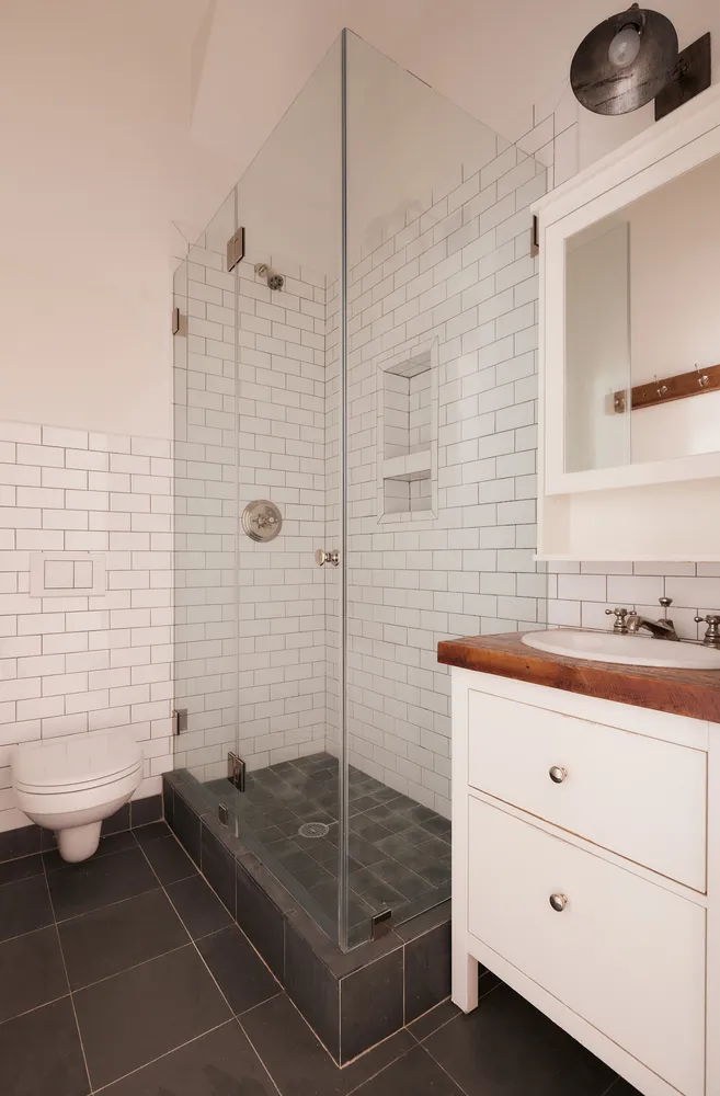 a bathroom with a granite countertop sink a toilet and shower