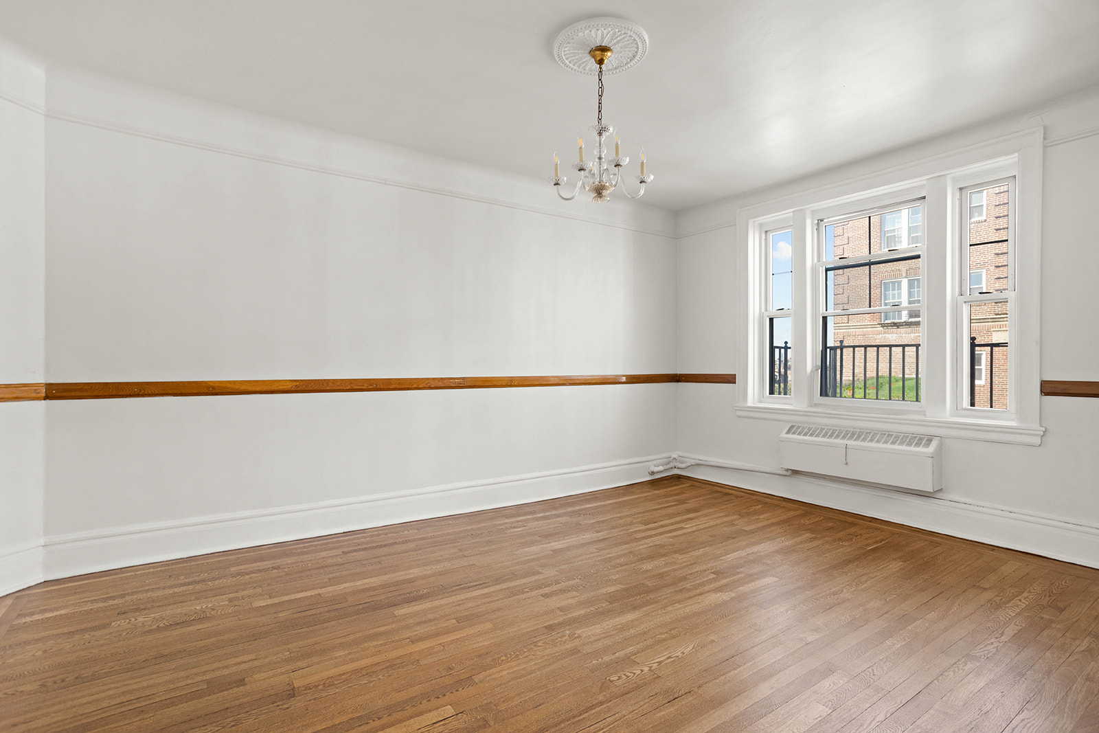 35-55 78th Street, Unit 42 Queens, NY 11372 - Photo 2 of 11 wooden floor in an empty room with a window