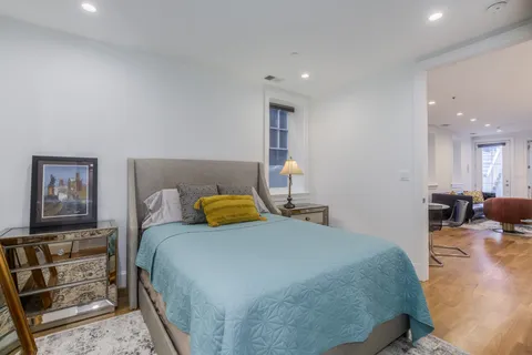 a bedroom with a bed and wooden floor