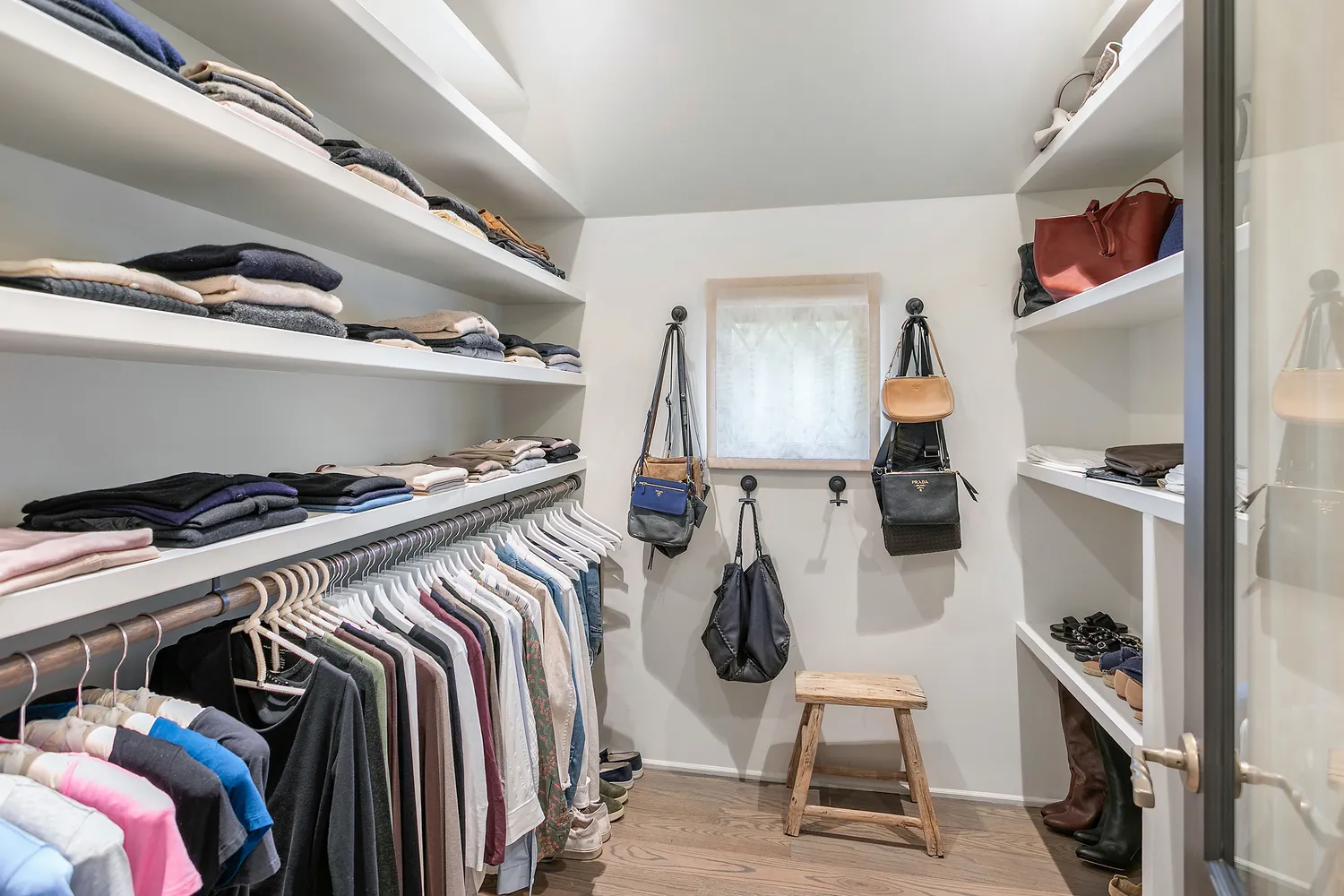 a view of walk in closet with clothes and shoes