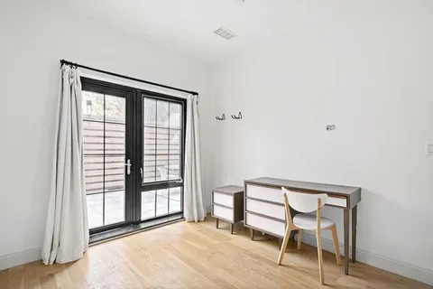 a view of a room with a window and wooden floor