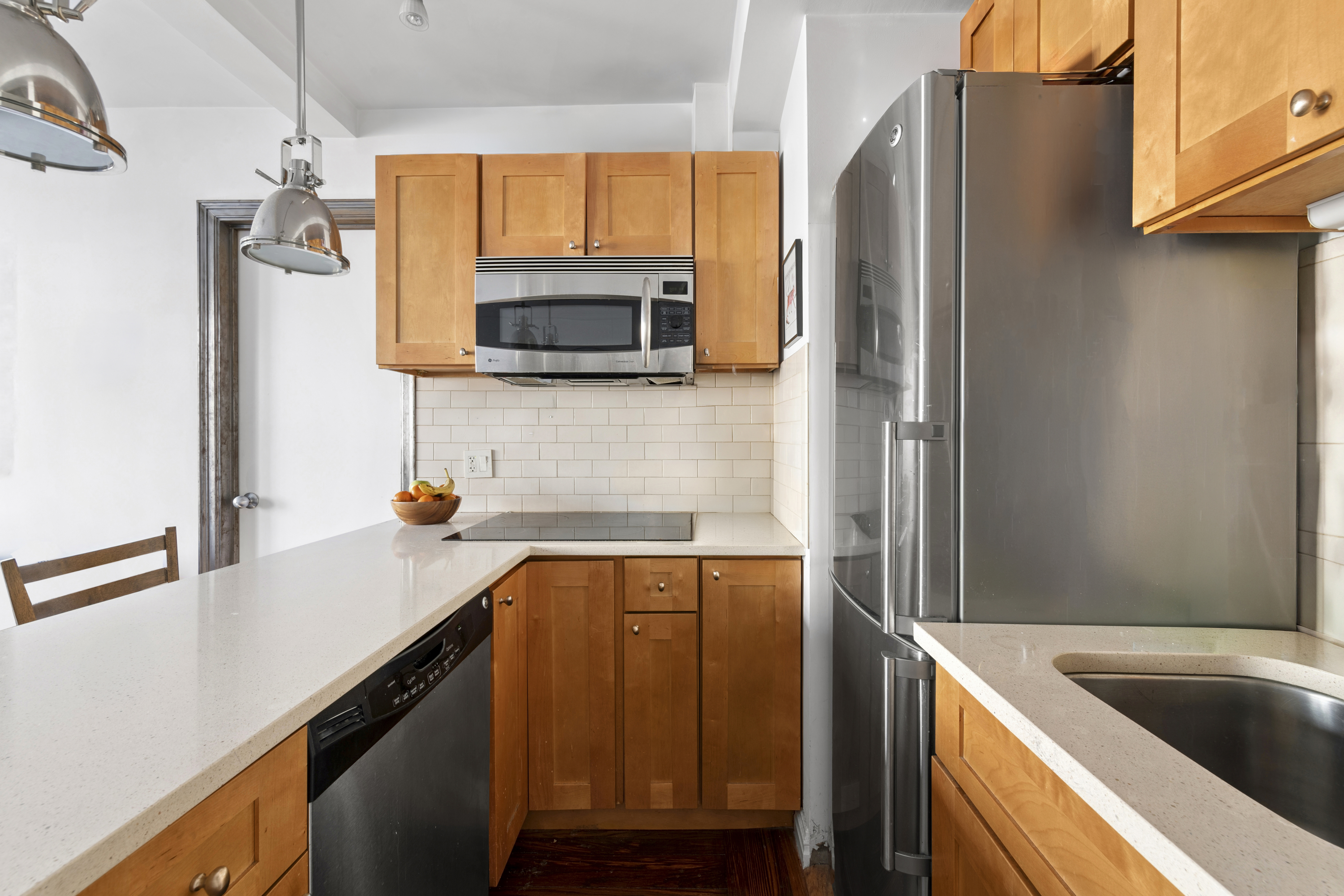 25 Tudor City Place, Unit 1611 Manhattan, NY 10017 - Photo 3 of 15 a kitchen with a refrigerator and a sink