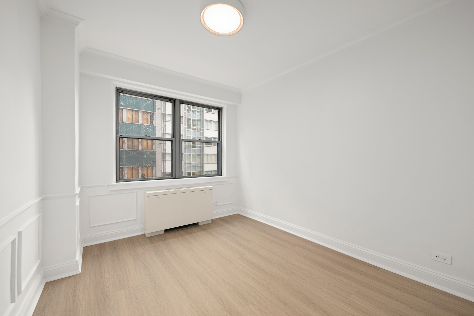 10 West 15th Street, Unit 414 Manhattan, NY 10011 - Photo 10 of 16 a view of an empty room with wooden floor and a window