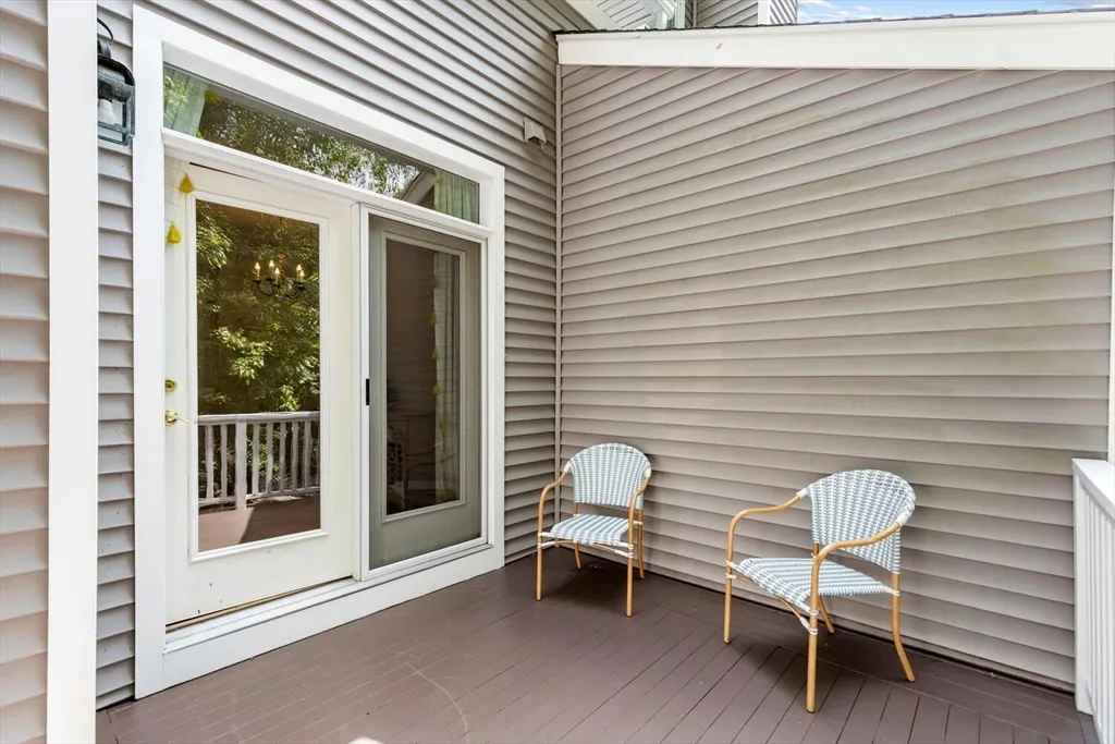 a porch with a chair and a potted plant
