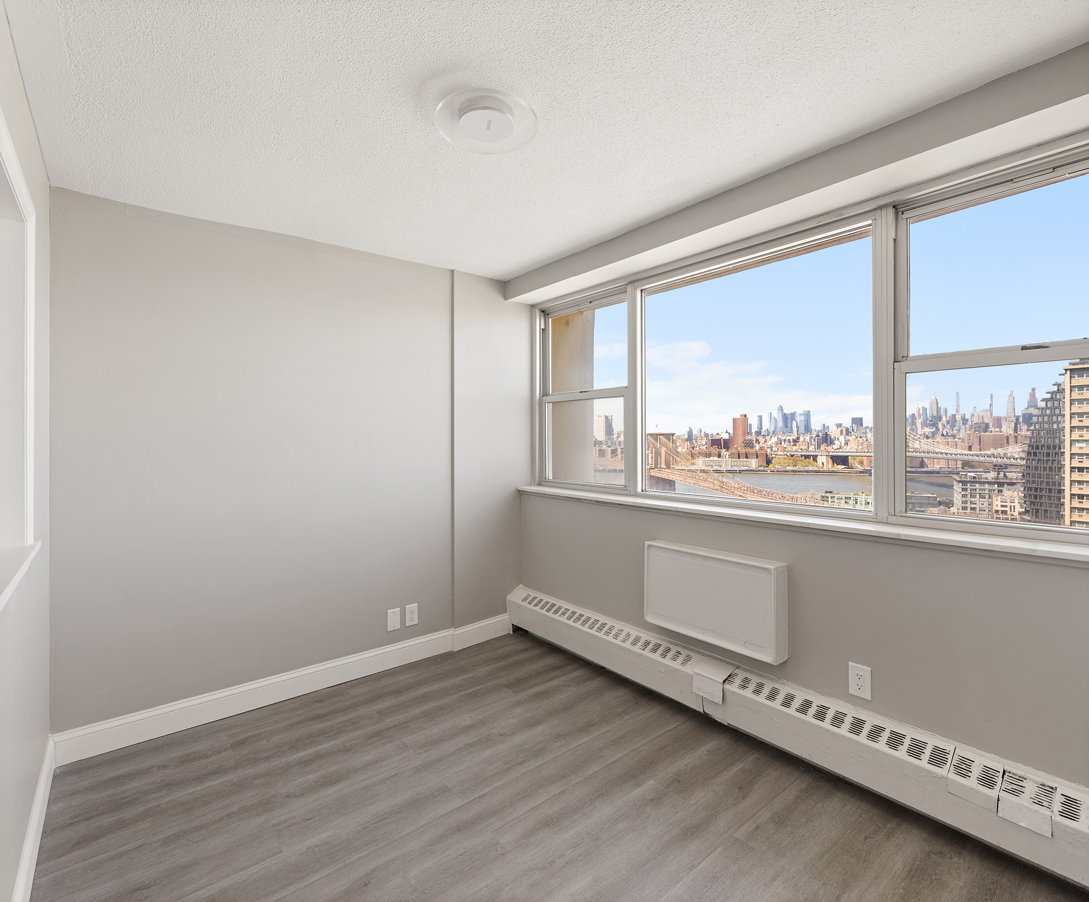 75 Henry Street, Unit 21C Brooklyn, NY 11201 - Photo 4 of 11 wooden floor in an empty room with a window