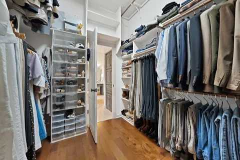 a view of walk in closet with clothes and shoes