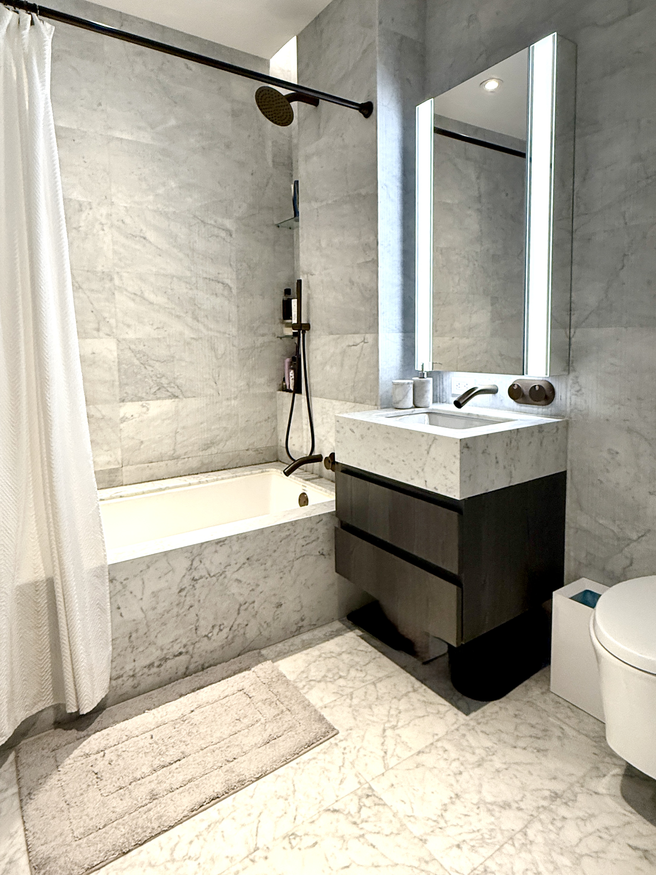 130 William Street, Unit 9E Manhattan, NY 10038 - Photo 4 of 16 a bathroom with a bathtub sink and mirror