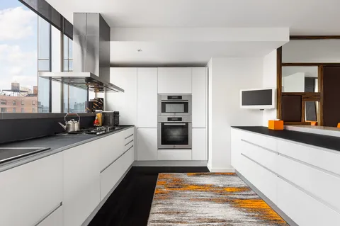 a kitchen with stainless steel appliances a stove a microwave and white cabinets