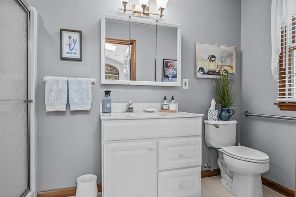 a bathroom with a sink a toilet and shower