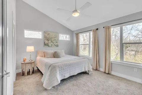 a bedroom with a bed and a large window