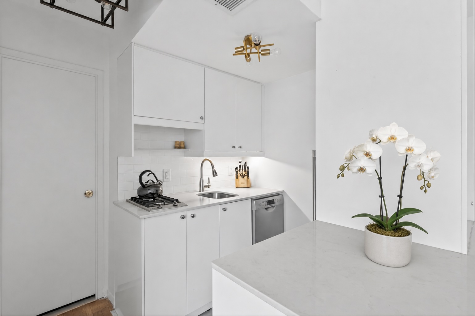 233 East 69th Street, Unit 16F Manhattan, NY 10021 - Photo 4 of 11 a kitchen with stainless steel appliances a sink and cabinets